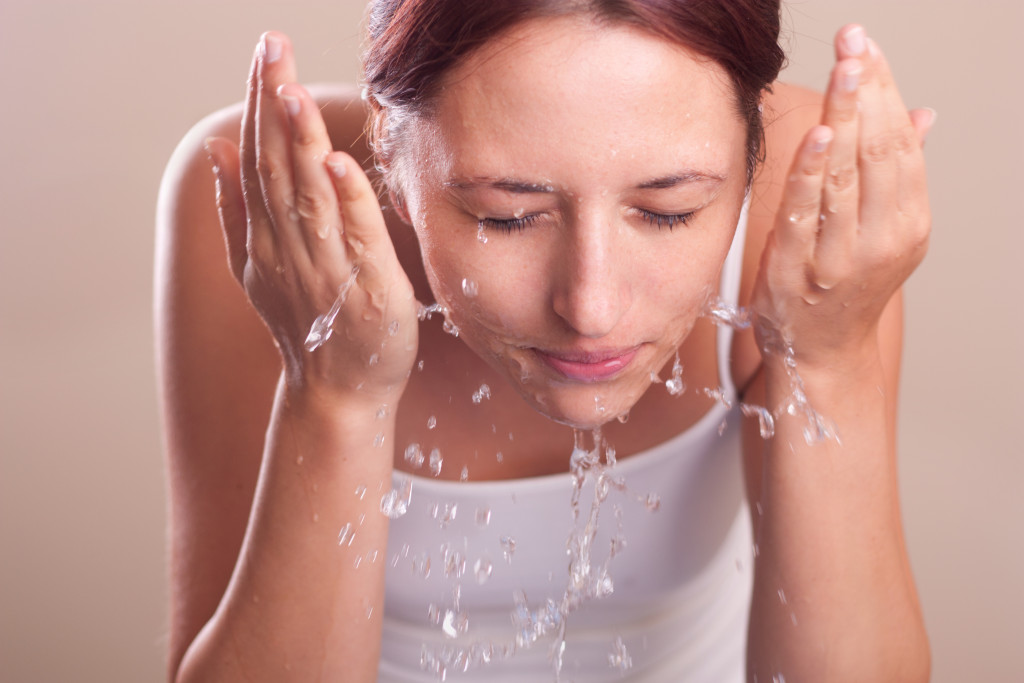 a woman splashing her face with water