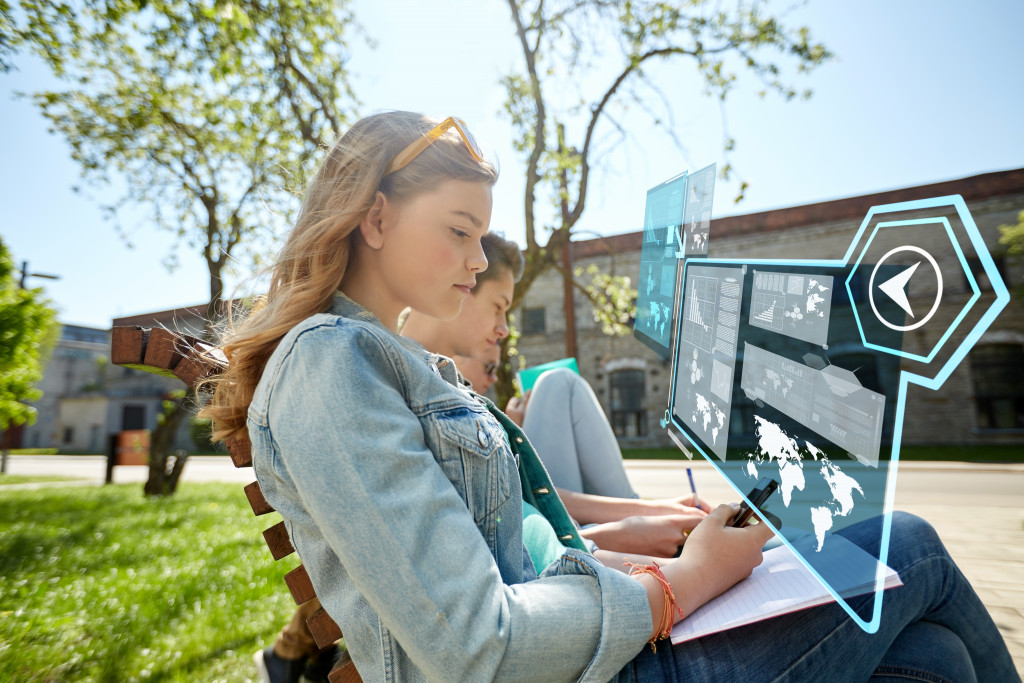 a woman holding a laptop with technology icons in front of her