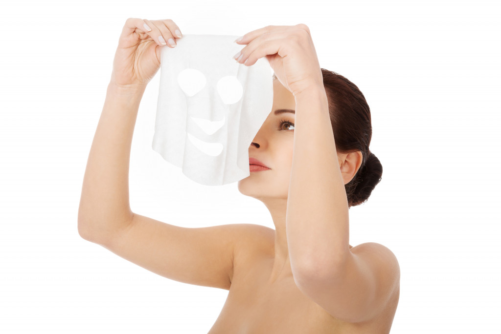 A woman putting on a collagen mask